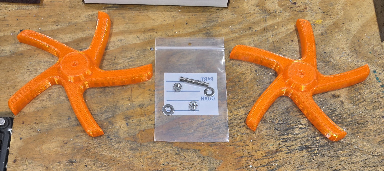 Two orange Chip Screen Spiders with stainless-steel installation hardware