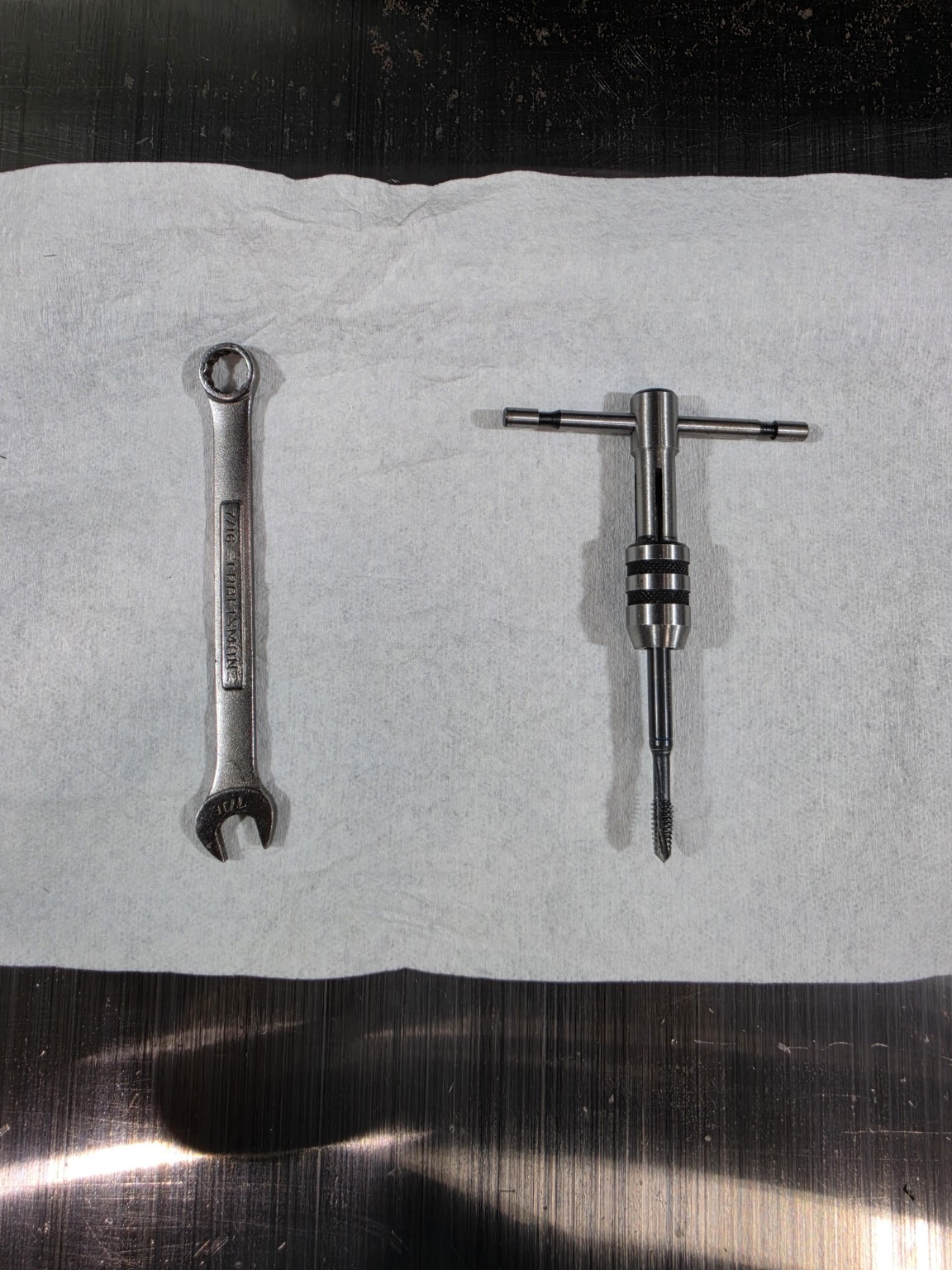 Tape measure, 1/4-20 tap and tap holder, and 7/16-inch wrench